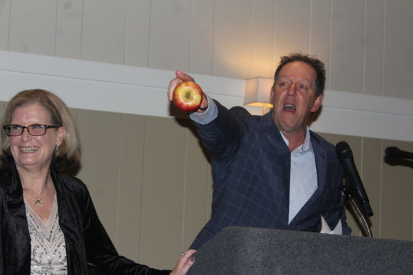 Select Board member Jeffrey Handler, next to Harwich Chamber of Commerce Executive Director Cyndi Williams, served as the live auctioneer, starting the bidding with n apple,
