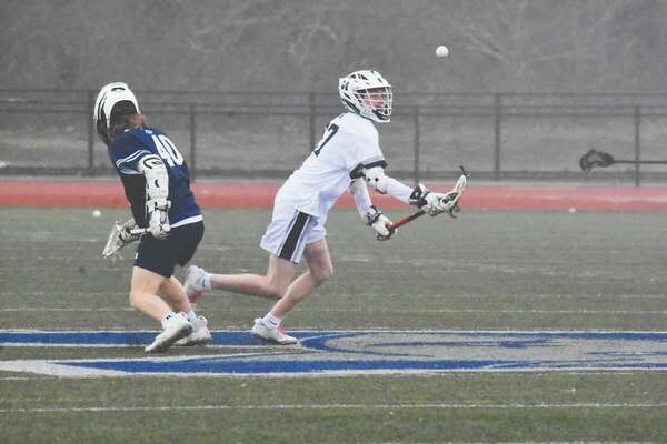 Monomoy junior Charles Hamilton scoops the ball out of mid-air after winning a faceoff.