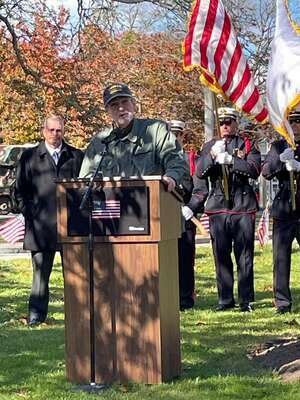 Andrew DeLory, a retired U.S. Army specialist, speaks to attendees from Veterans’ Memorial Park.