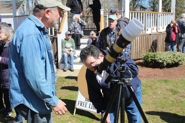 Frank Tavano of Harwich is with Larry Brookhart of Harwich Observatory viewing the eclipse through one of the observatory's solar scopes made available to the public for the event.