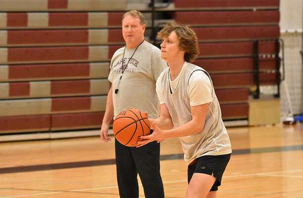 Cape Tech senior Trevor Ryone looks to shoot while Crusaders boys coach Brent Warren looks on during a recent practice.