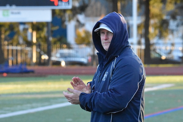 Monomoy field hockey coach Kyle Cappallo applauds his players as they walk off the field after Saturday's state championship.
